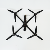 Black quadcopter FPV drone with four propellers and central frame