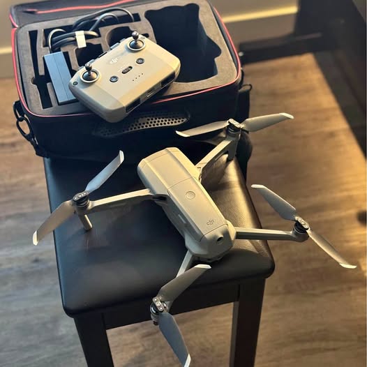 Foldable drone with controller, propellers, and hard case in gray and black