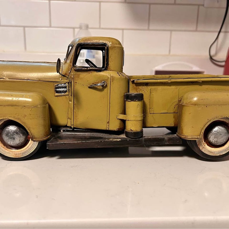 Light yellow diecast vintage model pickup truck, front cab and wheels visible