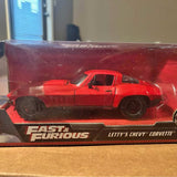 Red diecast Chevy Corvette coupe model in clear display box, black wheels