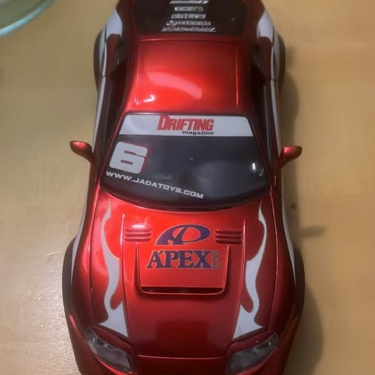 Red and black 1:18 die-cast sports car model, rear view with spoiler