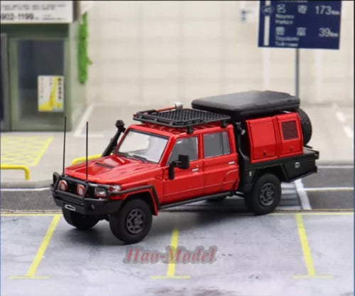 Red and black diecast SUV model car with roof rack, front three-quarter view