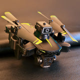 Three-camera folding quadcopter drone with front camera module, compact design