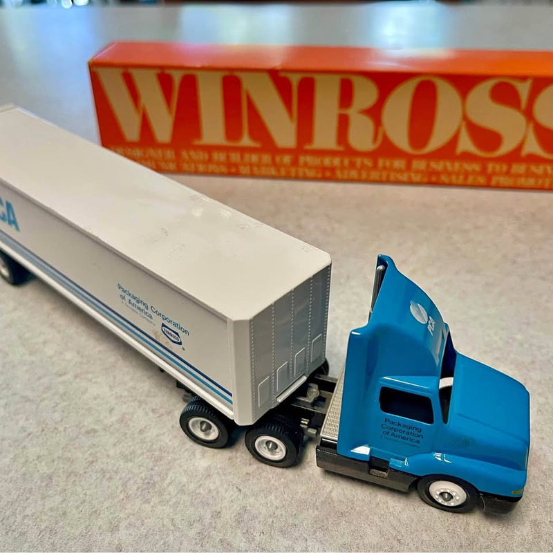 Diecast tractor-trailer replica with white box trailer and blue cab truck
