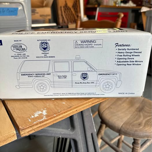 Die-cast model truck box with printed vehicle graphics and warning labels