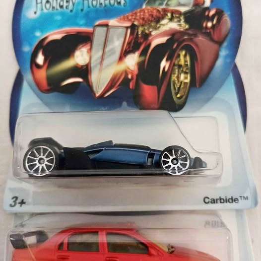 Hot Wheels diecast red hotrod car with black wheels, shown in clear blister pack