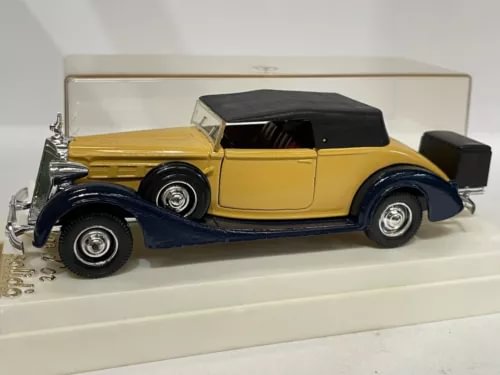 Yellow and dark-roof vintage diecast car model, front three-quarter view