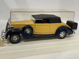 Yellow and dark-roof vintage diecast car model, front three-quarter view
