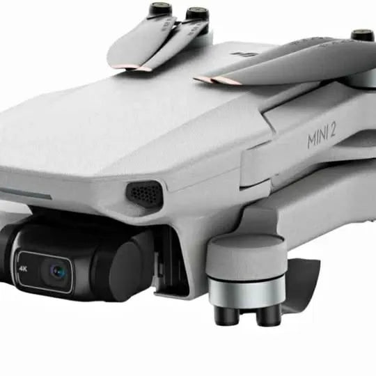 Gray mini drone with front camera lens and sensor, showing propeller arms