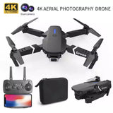 Black quadcopter drone with front camera, remote controller, and carrying case