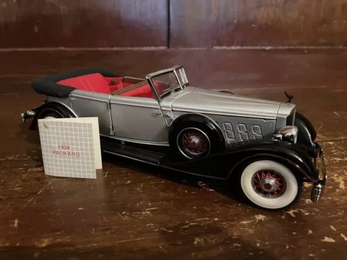 1:24 scale diecast replica car with black body, silver trim, red interior