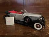 1:24 scale diecast replica car with black body, silver trim, red interior