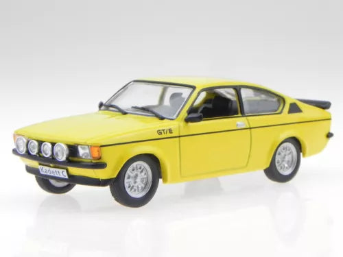 Yellow diecast coupe model car with black trim, front-left 3/4 view, chrome headlights