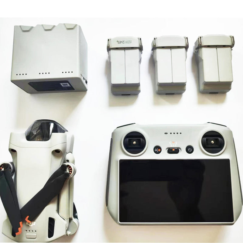 White drone with handheld remote controller, twin joysticks and front screen