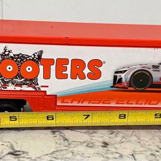 Orange and white diecast hauler truck with Hooters logo and black wheels