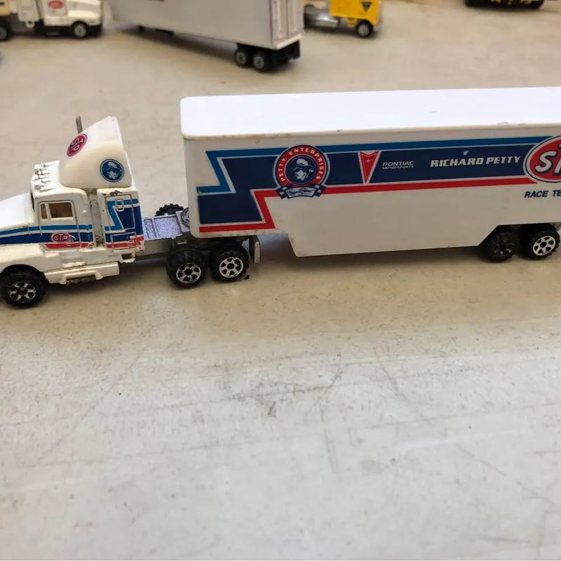 White diecast race tractor trailer with blue and red stripe graphics, side view.