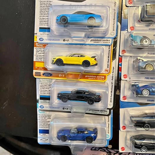 Collectible diecast cars in plastic blister packaging with visible blue and yellow models