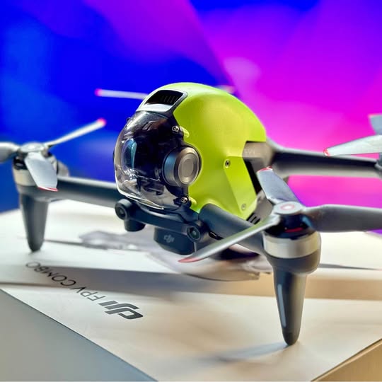 Multirotor drone with lime green nose and front camera, silver prop arms