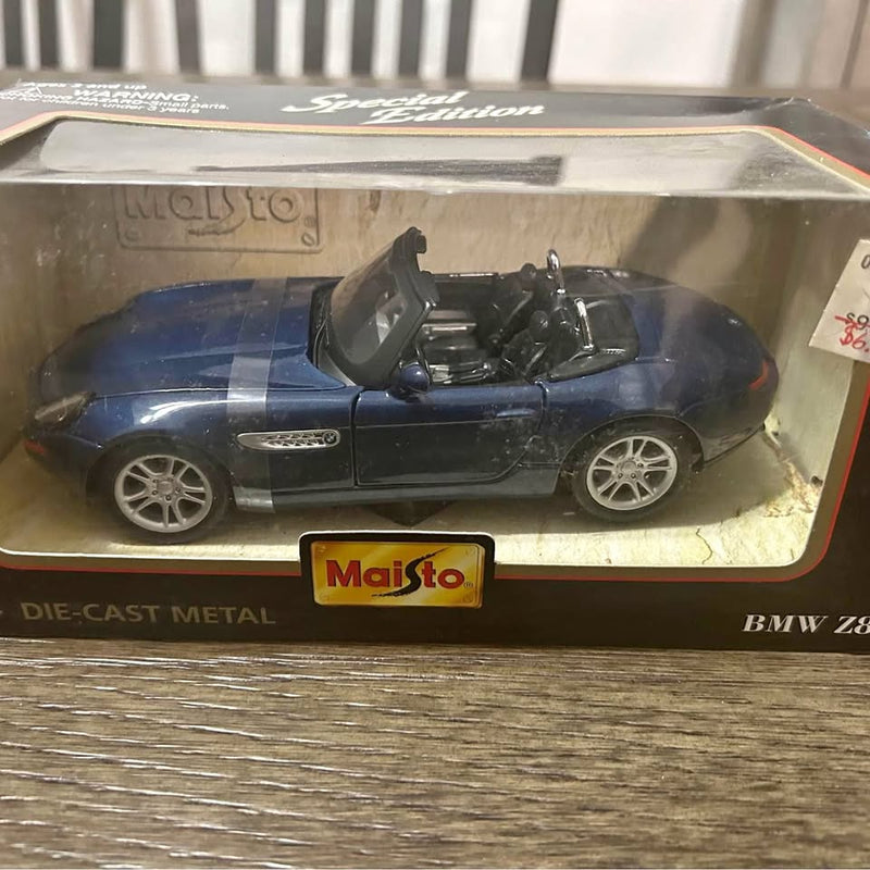 Blue diecast metal open-top sports car model with black interior and silver wheels.