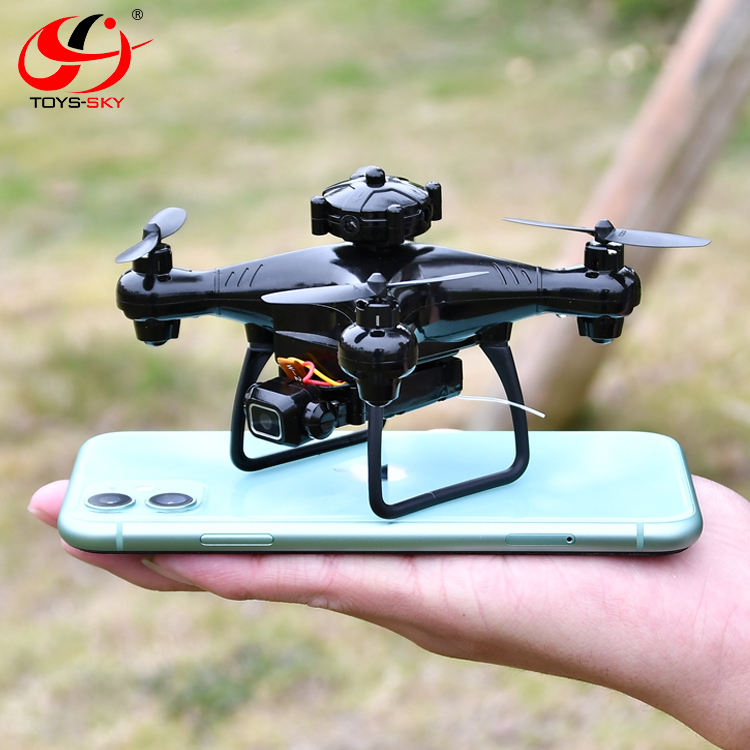 Small black quadcopter drone with camera, held above a mint smartphone controller