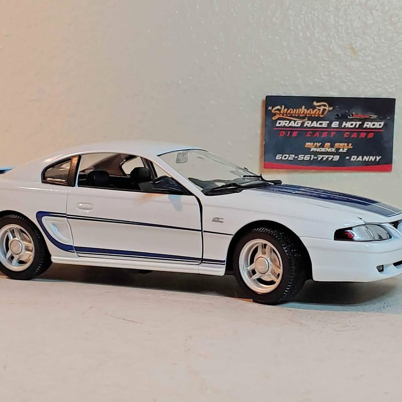 1:18 diecast Mustang model, white with blue stripes, black interior, side view