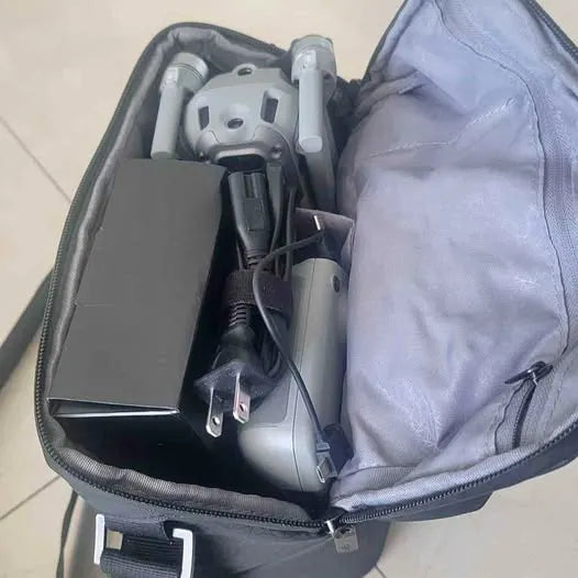 Drone inside gray zippered carrying case with folded propellers and cables