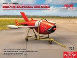 Red-and-white Firebee drone model on trailer cart, with stub wings and nose intake