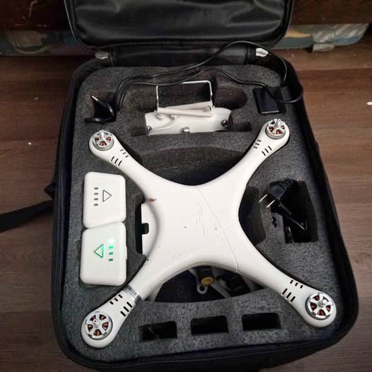 White quadcopter drone with four propellers in a padded carrying case