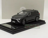 Black diecast car model, front three-quarter view on display base