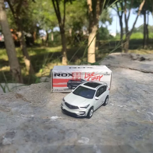 White 1:64 diecast Acura RDX SUV model car with box, front three-quarter view