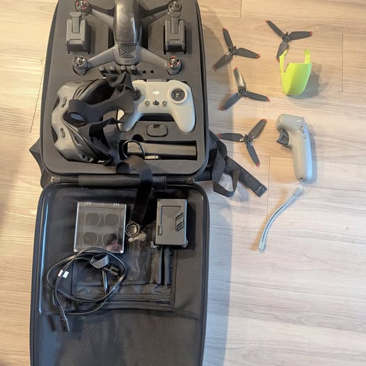 DJI FPV drone kit in black carry case with remote, goggles, and spare parts