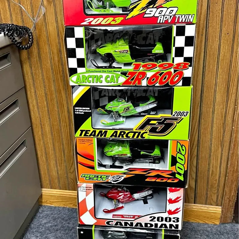 Boxed Arctic Cat diecast snowmobile models with green and black graphics