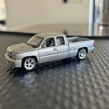 Diecast pickup truck, silver-gray with chrome wheels and black grille