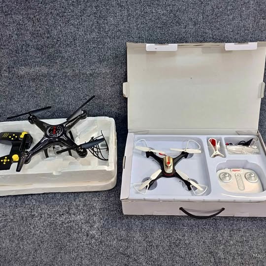 Black quadcopter drone with controller and accessories in open white case