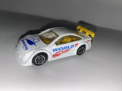 White 1:60 diecast racing car with World Cup graphics and yellow rear spoiler