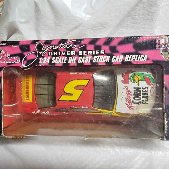Die-cast stock car replica in blister pack, red and yellow race car