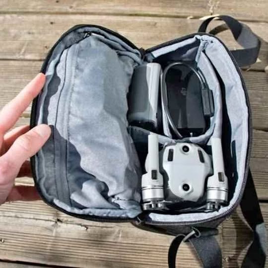 Foldable drone in open carrying case, controller mount and landing gear visible