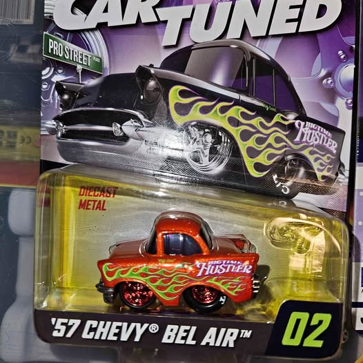 Die-cast car model in blister pack, red and yellow flame graphics, front view