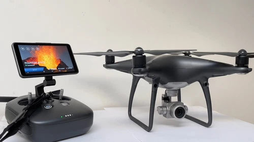 Black quadcopter drone with front camera and gimbal, plus handheld controller screen
