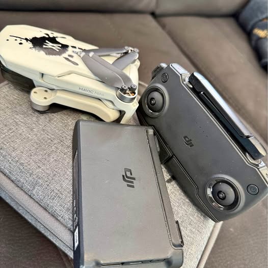 DJI Mavic Mini drone and black remote controller with screen and joysticks