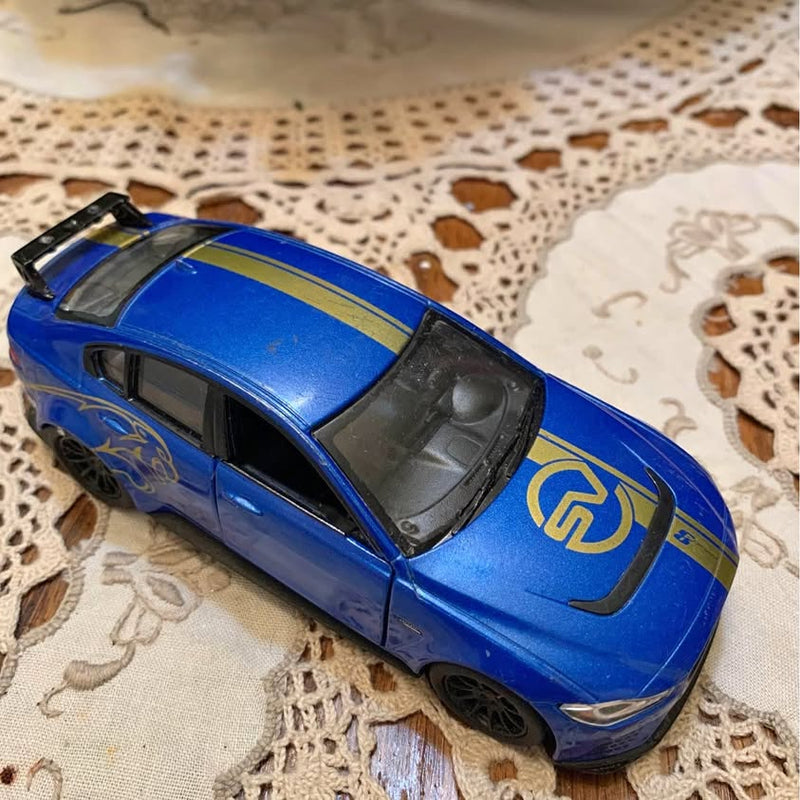 Blue Jaguar XE SV diecast car with black wheels, side front view, racing stripe on hood