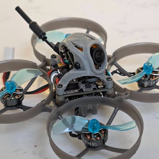 RC quadcopter drone with front camera and exposed circuit board, gray frame