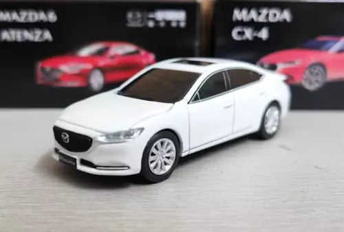 White diecast sedan model car, front three-quarter view with chrome grille and headlights