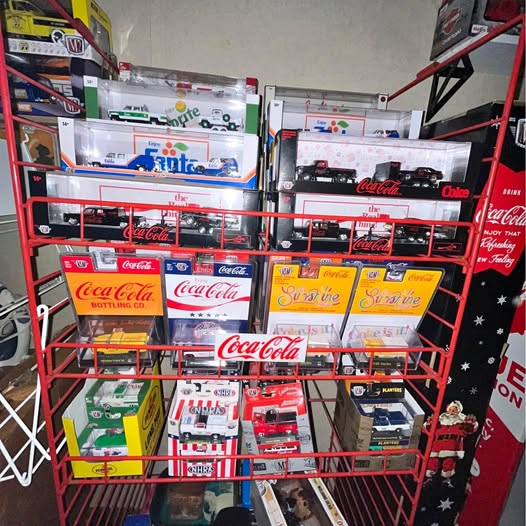 Diecast car collection display rack with multiple cars and Coca-Cola branding