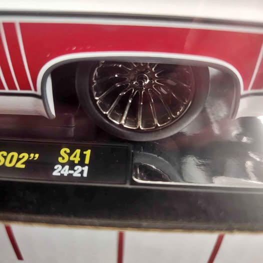 Diecast truck front with chrome wheel and dark grille, red and white body