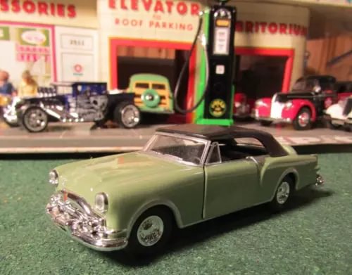 Olive green 1953 Packard Caribbean soft-top diecast car, front three-quarter view