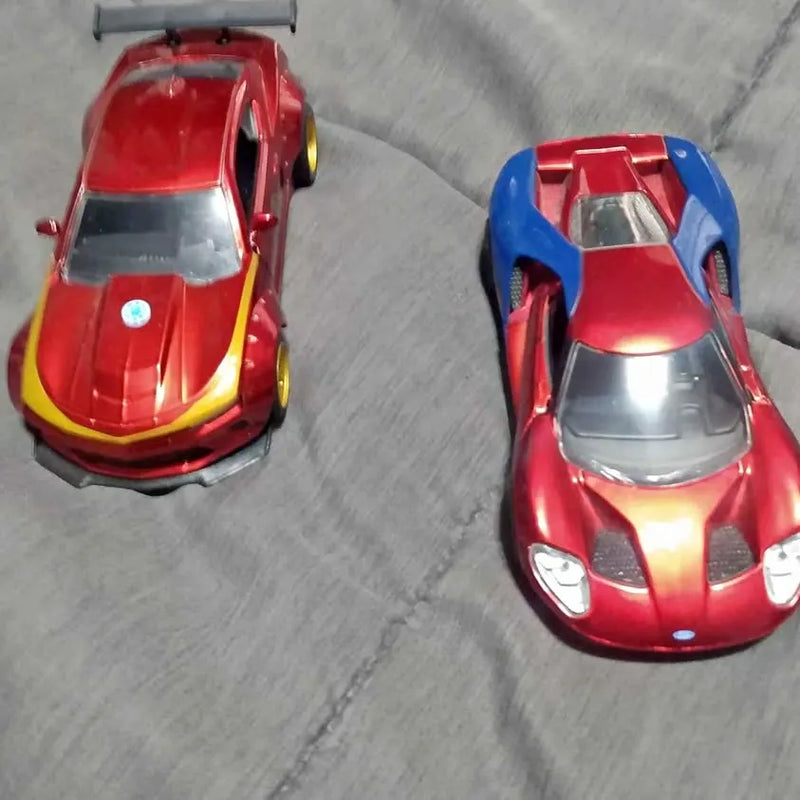Two 1/32 diecast sports cars, red bodies with blue and yellow accents
