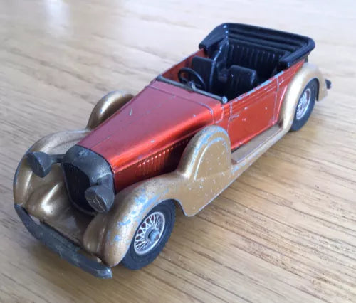 Diecast vintage open-top car model, red body with black interior and chrome bumper.