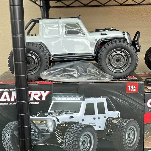 White RC off-road truck toy with large rugged tires, shown in retail packaging