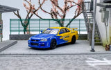 Diecast sports model car with blue body and yellow accents, front 3/4 view